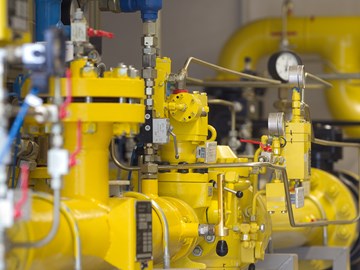 Gelbe Rohre einer Anlage mit vielen Hebeln, Leitungen und Messanzeigen Gelbe Rohre einer Anlage mit vielen Hebeln, Leitungen und Messanzeigen