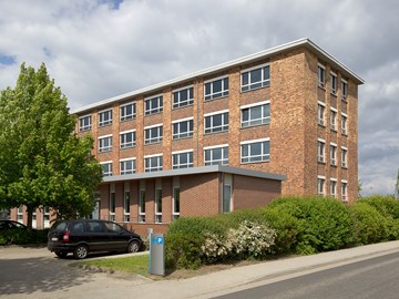 Backsteingebäude mit Parkplatz - Außenaufnahme Backsteingebäude mit Parkplatz - Außenaufnahme