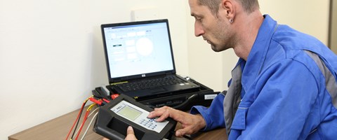 Techniker sitzt mit portable Eingabegerät und Laptop an einem Tisch Techniker sitzt mit portable Eingabegerät und Laptop an einem Tisch