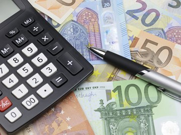 Taschenrechner und Kugelschreiber auf Eurobanknoten unterschiedlicher Werte - Nahaufnahme Taschenrechner und Kugelschreiber auf Eurobanknoten